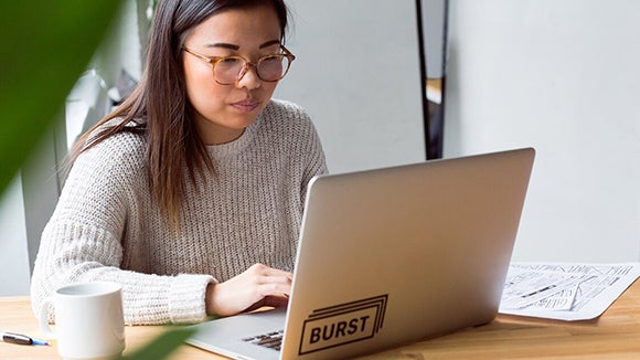 employee on laptop with headphones accessing Robert Walters Outplacement Services Career Toolkit